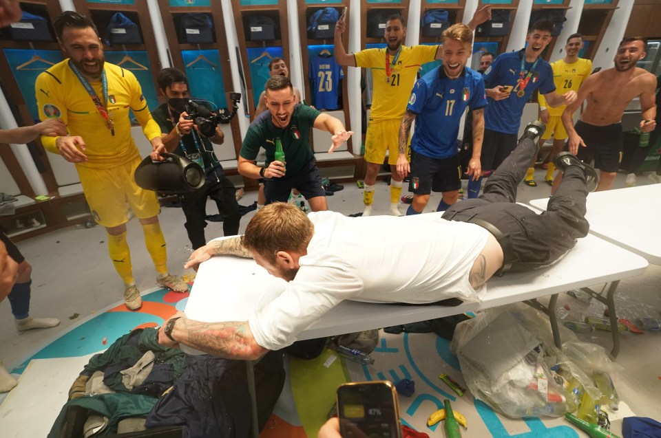 Almost there - as Azzurri legend Daniele De Rossi reaches the end of the table after an epic slide in the Wembley dressing rooms