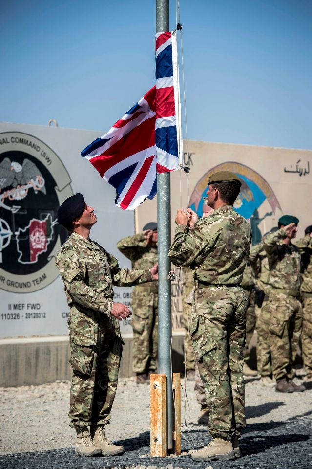 The last Union flag of Great Britain flying above the skies of Helmand Province, Afghanistan, is lowered by Captain Matthew Clark, left, and Warrant Officer 1 John Lilley