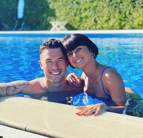 a man and woman are posing for a picture in a swimming pool