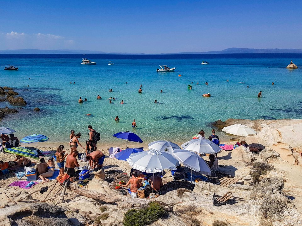 Tourists enjoy the beach in Kavourotrypes, Greece