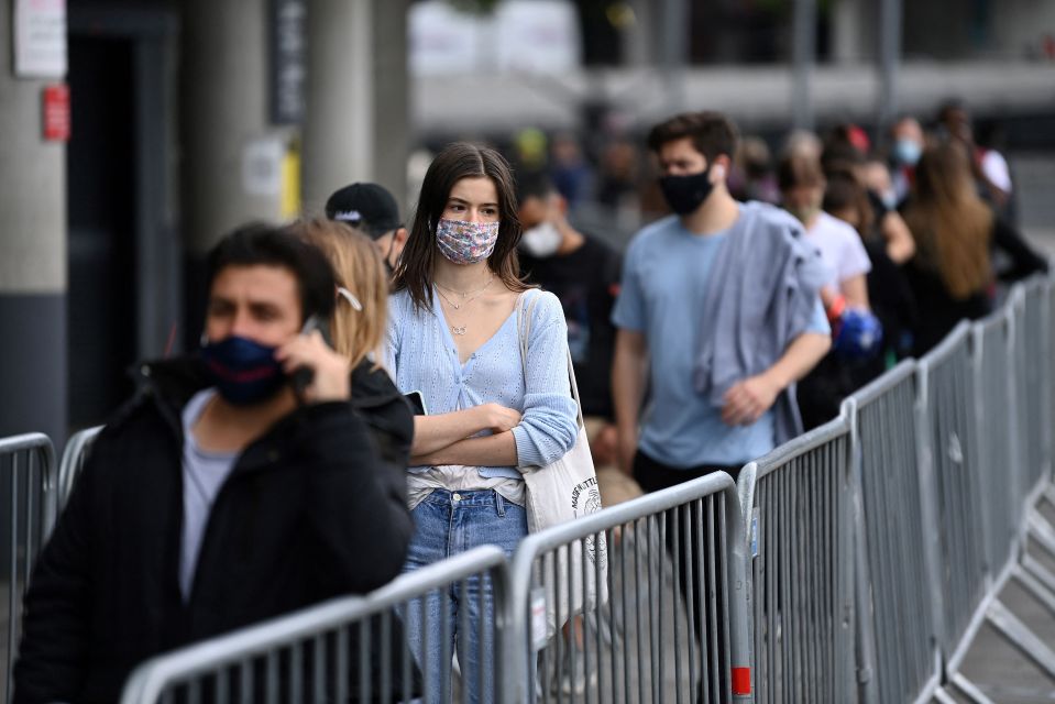 People queue to receive a Covid jab at a vaccine centre at the Emirates Stadium in London