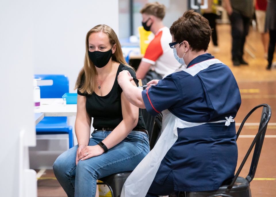 A woman receives a Pfizer jab at a mass coronavirus vaccination centre at Adwick Leisure Centre, in Doncaster