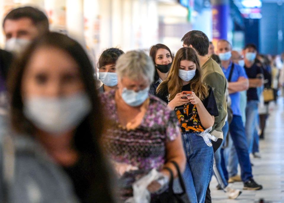 People wearing protective face masks queue for their vaccination at a shopping mall in Moscow, Russia, on July 2