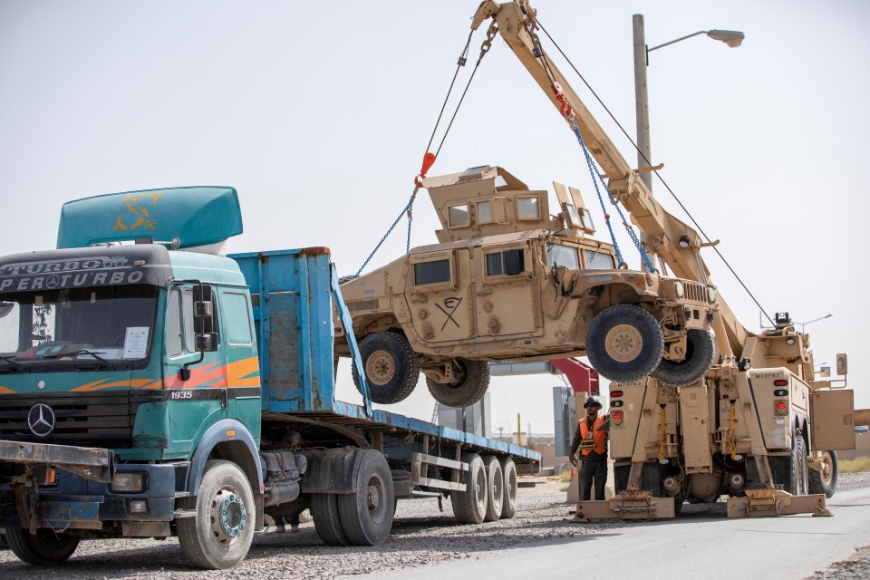 US soldiers load an armoured HUMV that's to be shipped back home