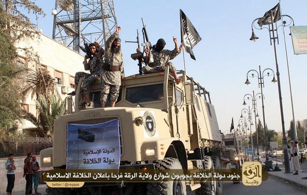 ISIS fighters celebrate on top a seized truck