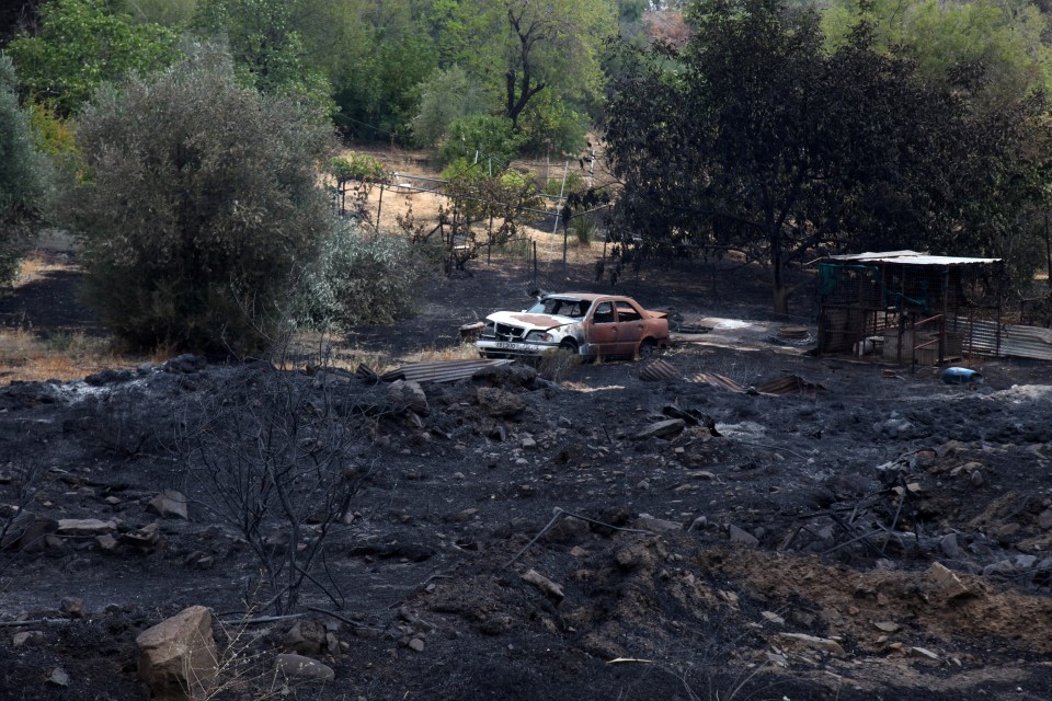 A burned out car sits amongst the rubble