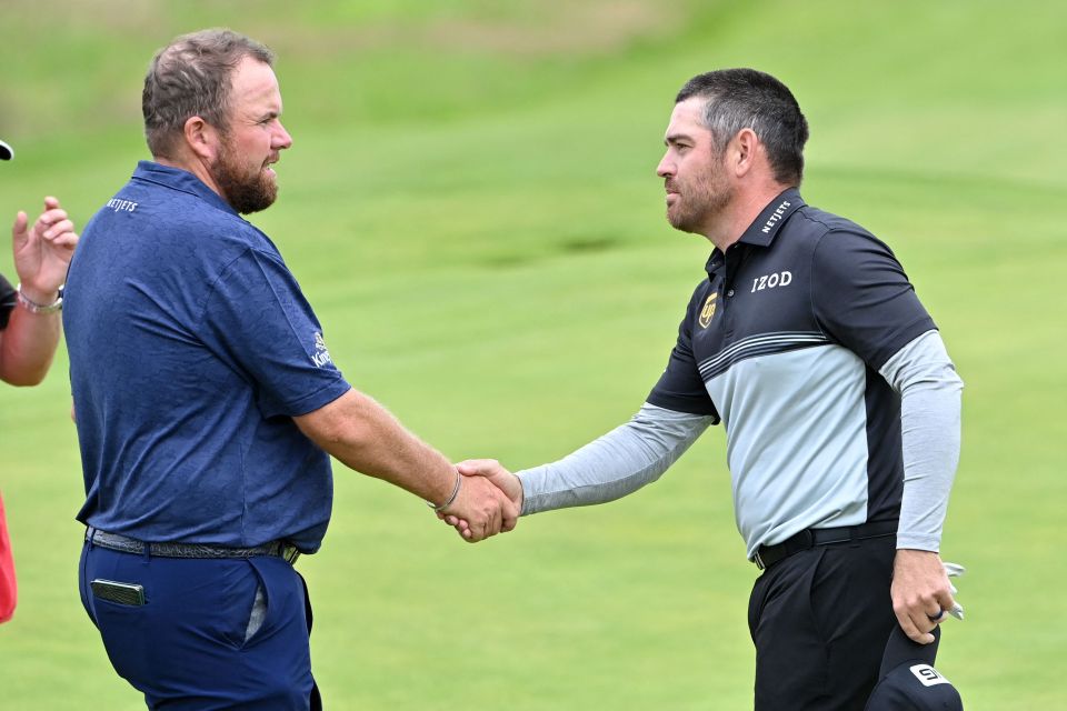 Louis Oosthuizen shakes hands with 2019 winner Shane Lowry after a first round 64 that gave him the lead