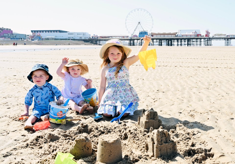 Frankie Fraser, two, Rosie Travis, two, and Emily Travis, five, enjoy Blackpool Beach