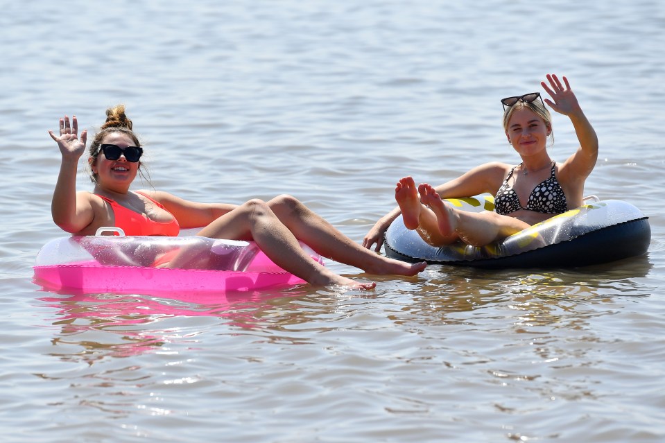 Lauren Tudge and Hannah Laschke cool off in the sea at Barry Island in South Wales