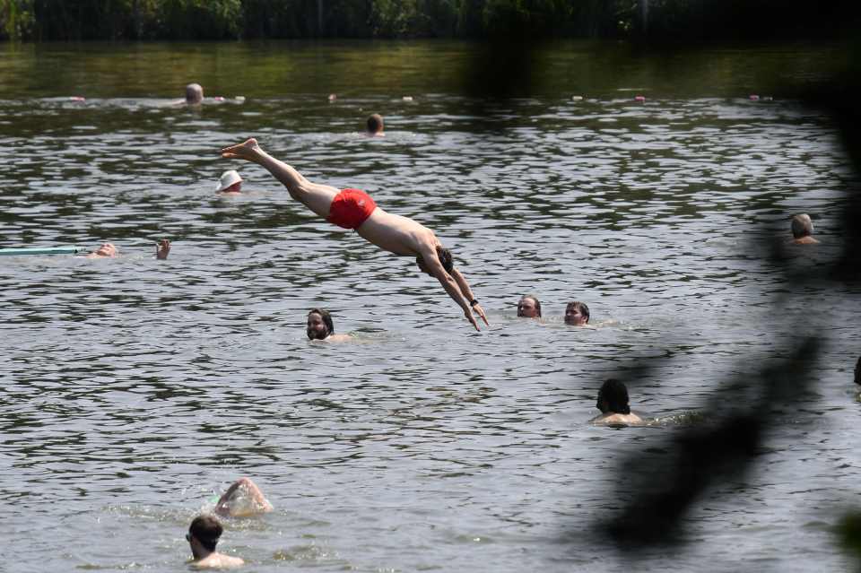 A swimmer jumps into the bathing pond in Hampstead Heath