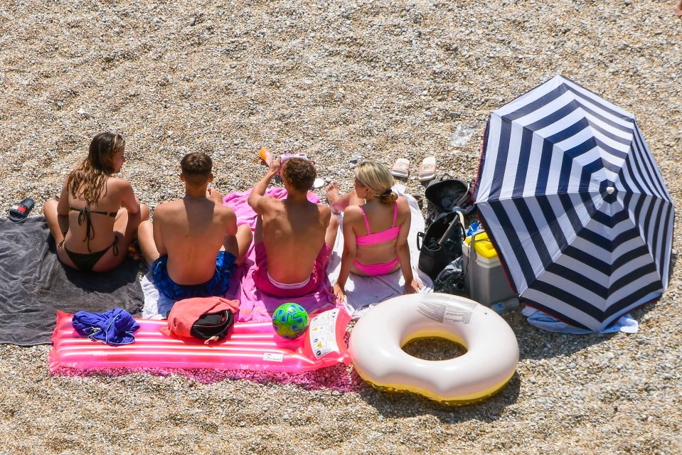 Sunbathers relaxing on the beach at Durdle Door in Dorset