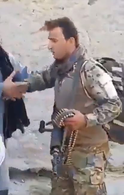 Afghan soldiers shake hands with Taliban forces as their give away their weapons