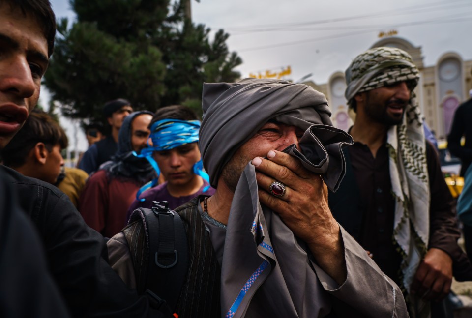 A man cries as he watches fellow Afghans get wounded by Taliban fighters