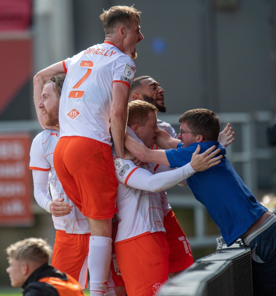 Blackpool players celebrate a goal with a fan during the match with Bristol City