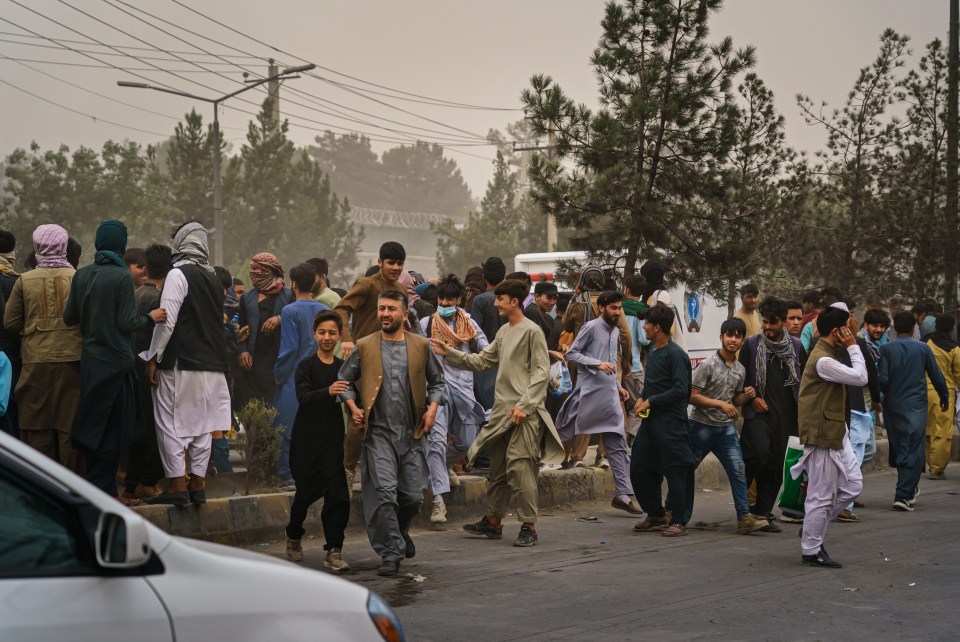 Afghans run away after Taliban fighters use guns fire sharp objects to maintain crowd control