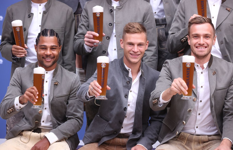 Bayern Munich's squad pose wearing lederhosen and holding beer