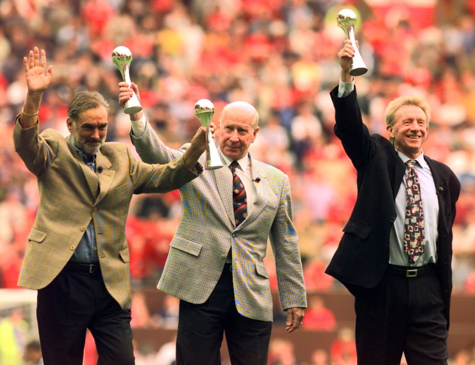 George Best, Bobby Charlton, and Denis Law holding trophies at a Manchester United event.