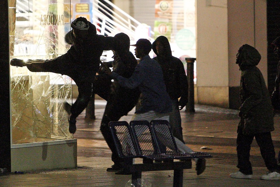 Looters break a shop window in the Bullring, Birmingham