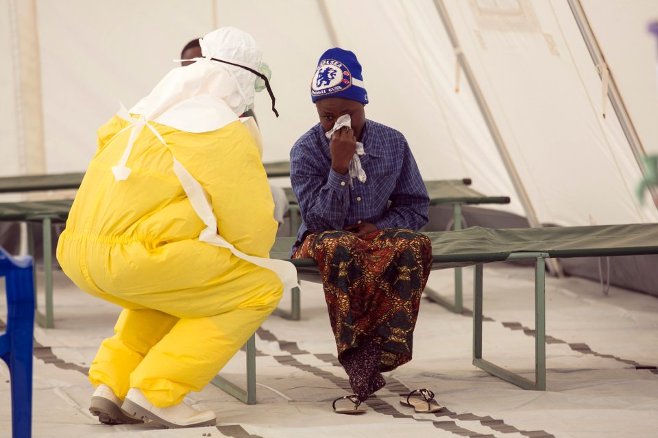 A medic speaking to a patient during the Ebola outbreak in West Africa