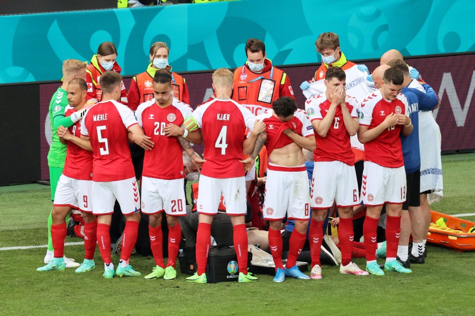 The Denmark team gather around Christian Eriksen as medical staff resuscitate him on the pitch at a Euro 2020 game in the summer