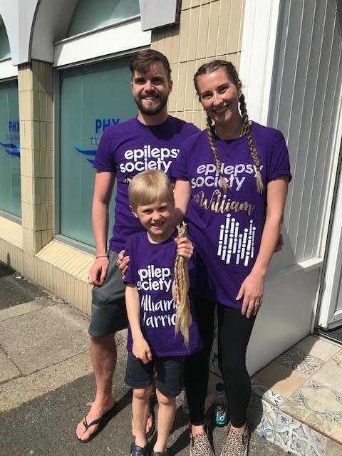 Thomas is pictured above with his mum and dad after having his plaits chopped off