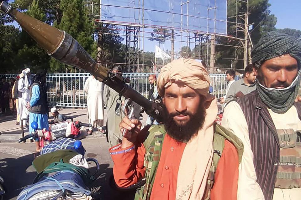 A Taliban fighter holds a rocket-propelled grenade (RPG) along the roadside in Herat