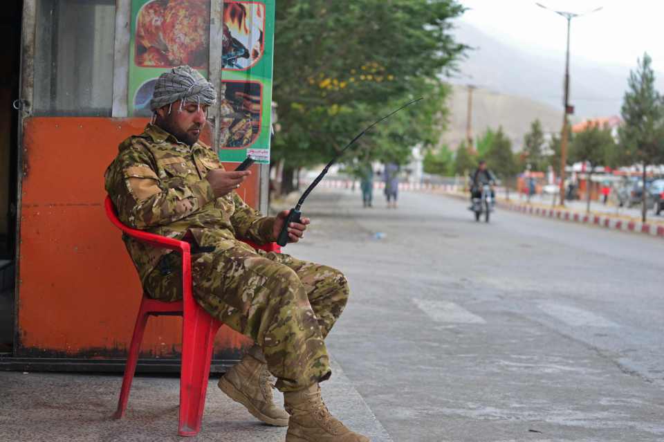 A member of the Afghan security force sits along the roadside in Panjshir province on August 14