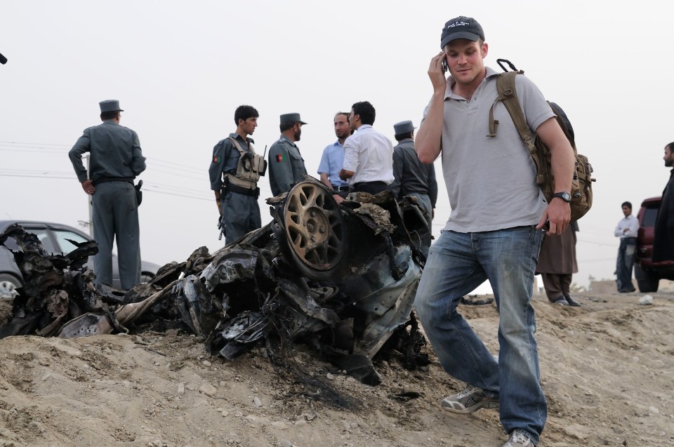 Standing beside the remains of a car