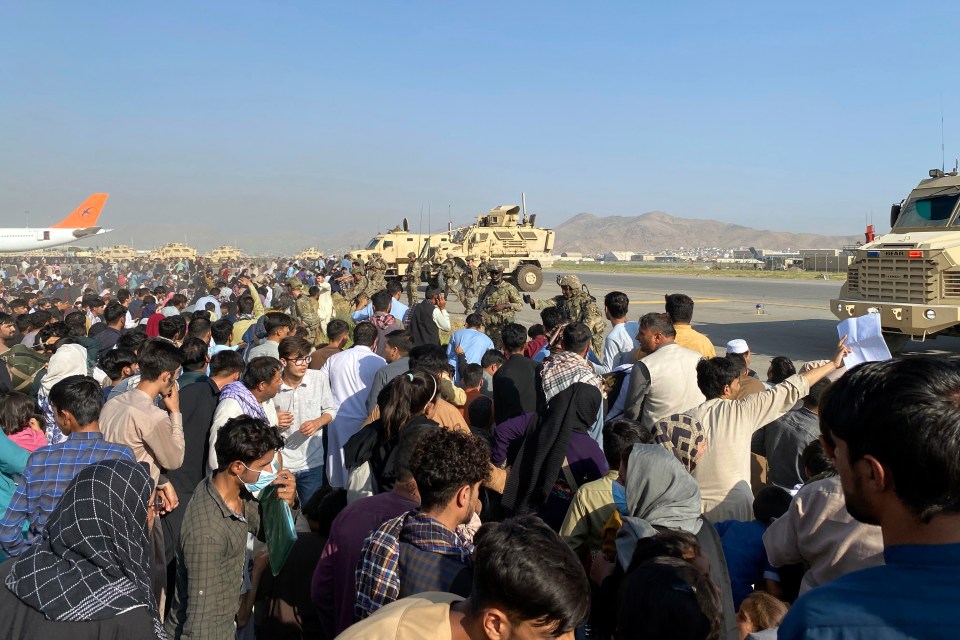 Thousands of Afghans gather at Kabul airport as US troops try to keep order