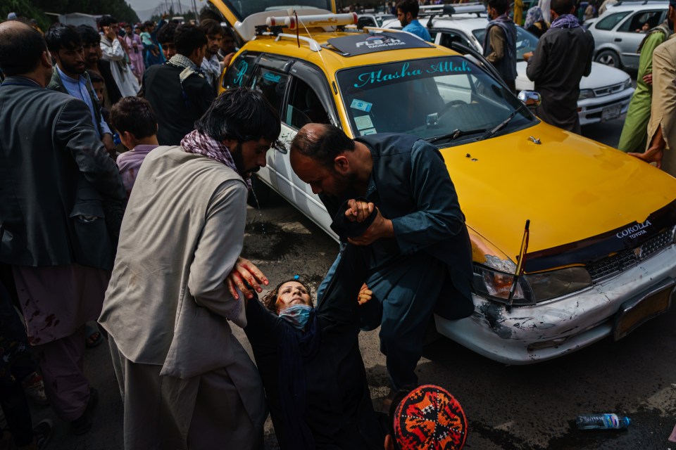 Men try to help a wounded woman and her wounded child