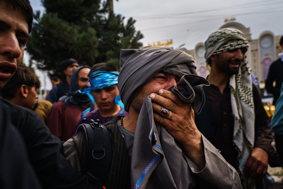 A man cries as he watches fellow Afghans get wounded