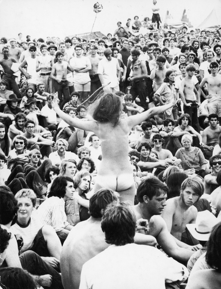 A naked woman dances amid the crowds at Woodstock '69