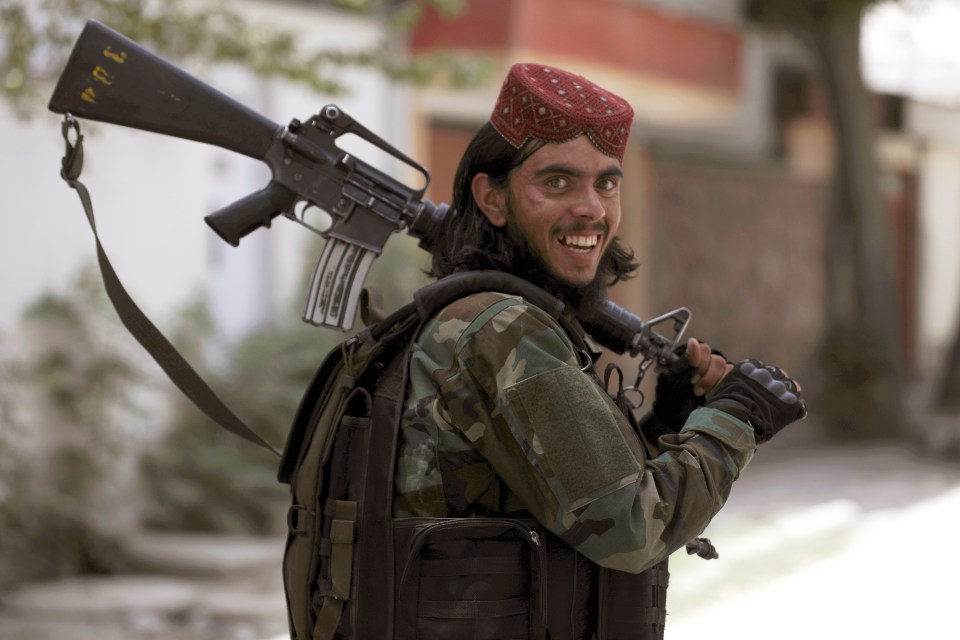 A Taliban fighter grins as his comrades show their true face with brutality unleashed against demonstrators