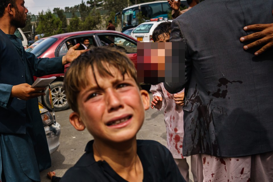 A boy was distraught after militants beat back families at Kabul airport