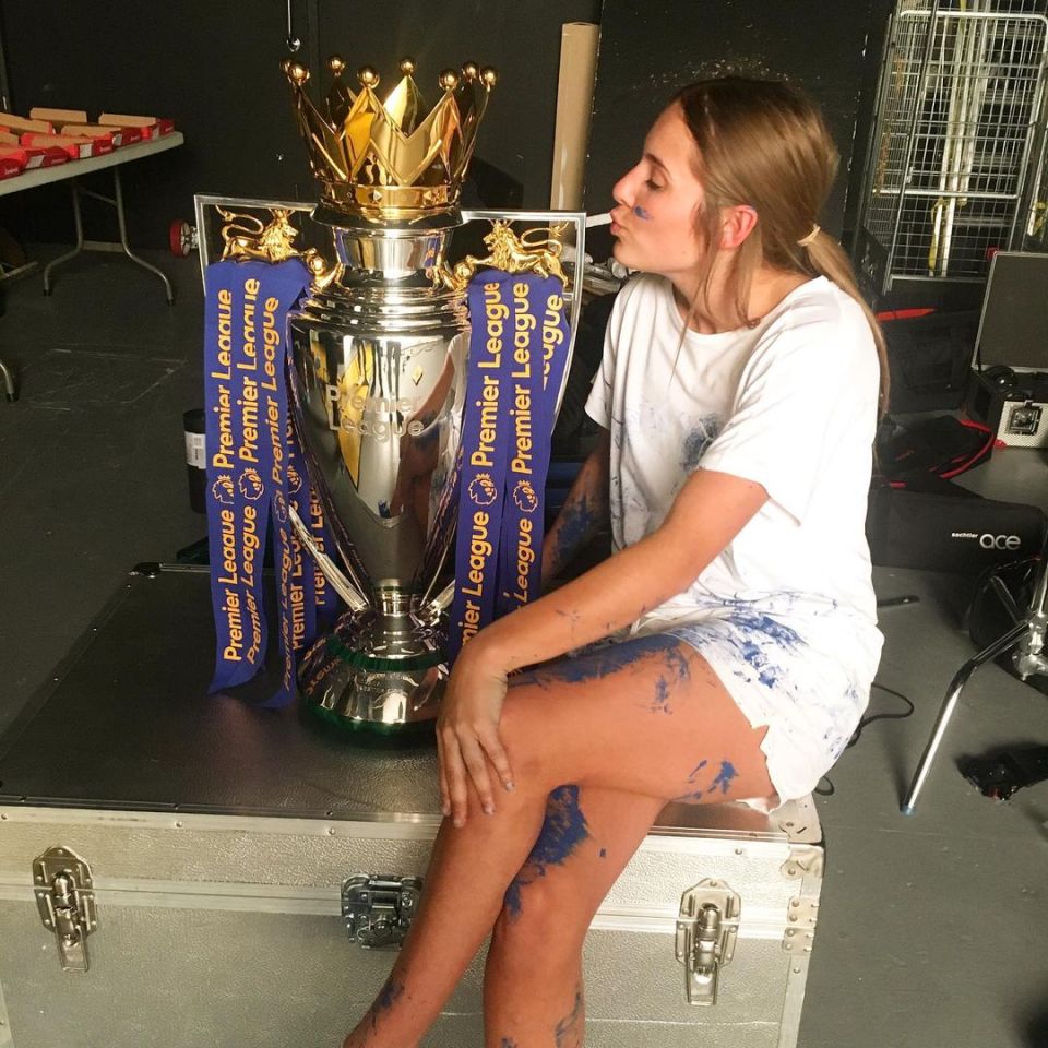 Olivia cuddles up to the Premier League trophy