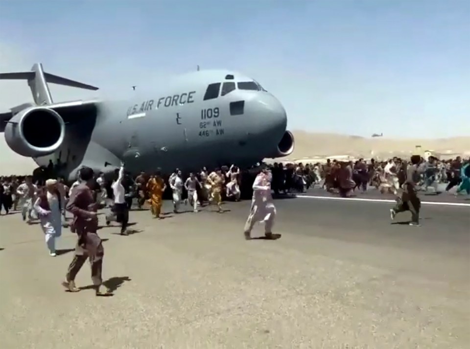 Hundreds of people run alongside a US Air Force C-17 transport plane