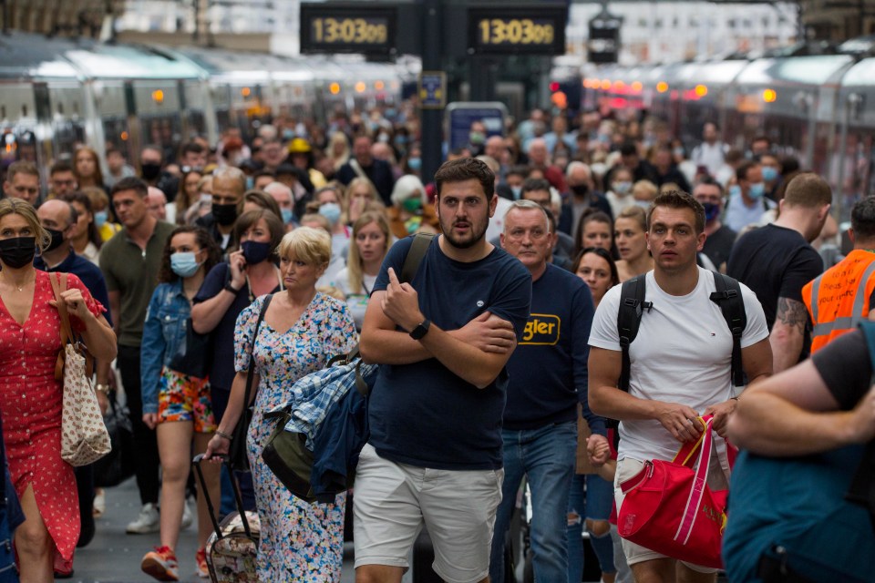 Train passengers are seen arriving in King's Cross station in London today