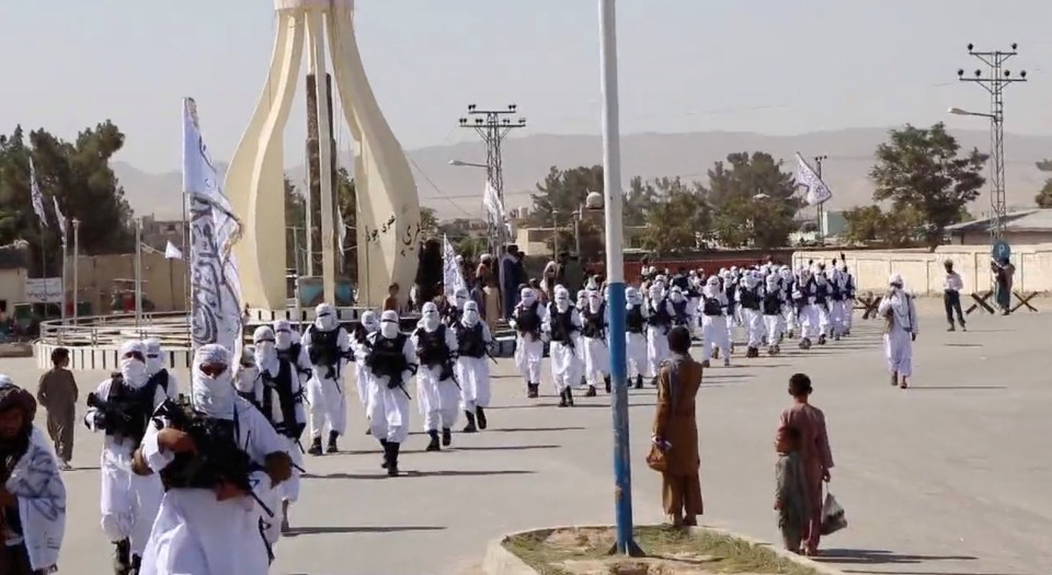 Civilians watch on as the Taliban fighters put on a show of strength