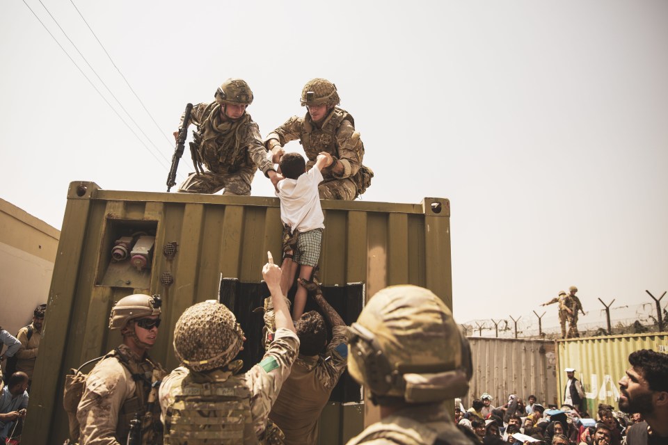 US Marines help an Afghan child as they attempt to evacuate refugees