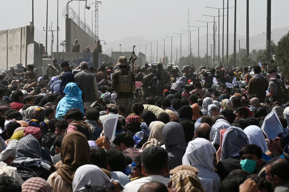 Afghans sit in the blazing heat outside hoping to get flights out of Kabul