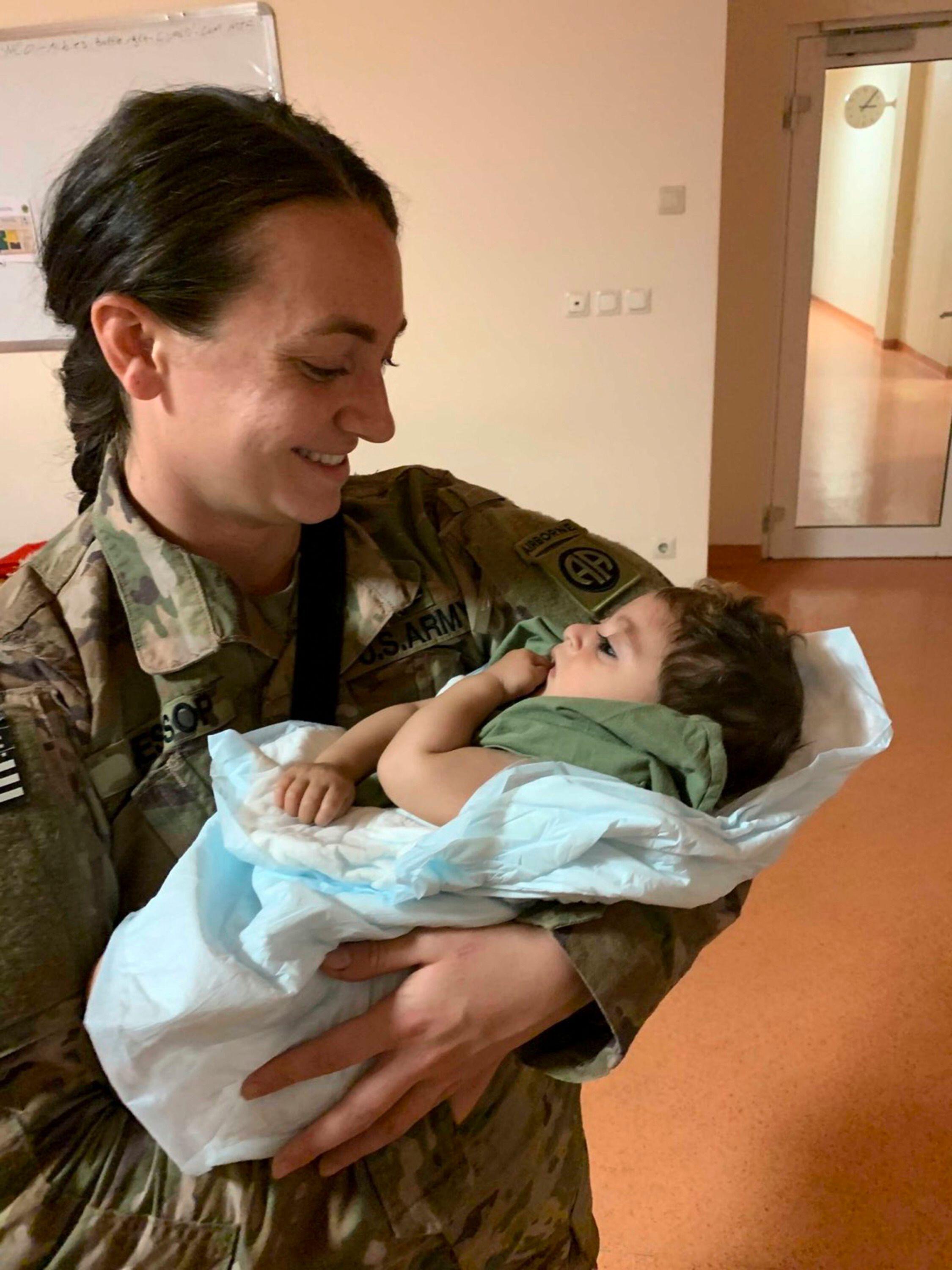 U.S. Army Sergeant Breanna Jessop with the 82nd Airborne Division, takes care of an unaccompanied infant