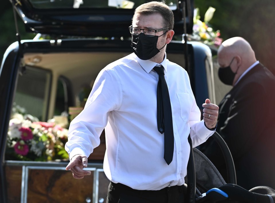 A mourner is seen outside the church as the coffin arrives