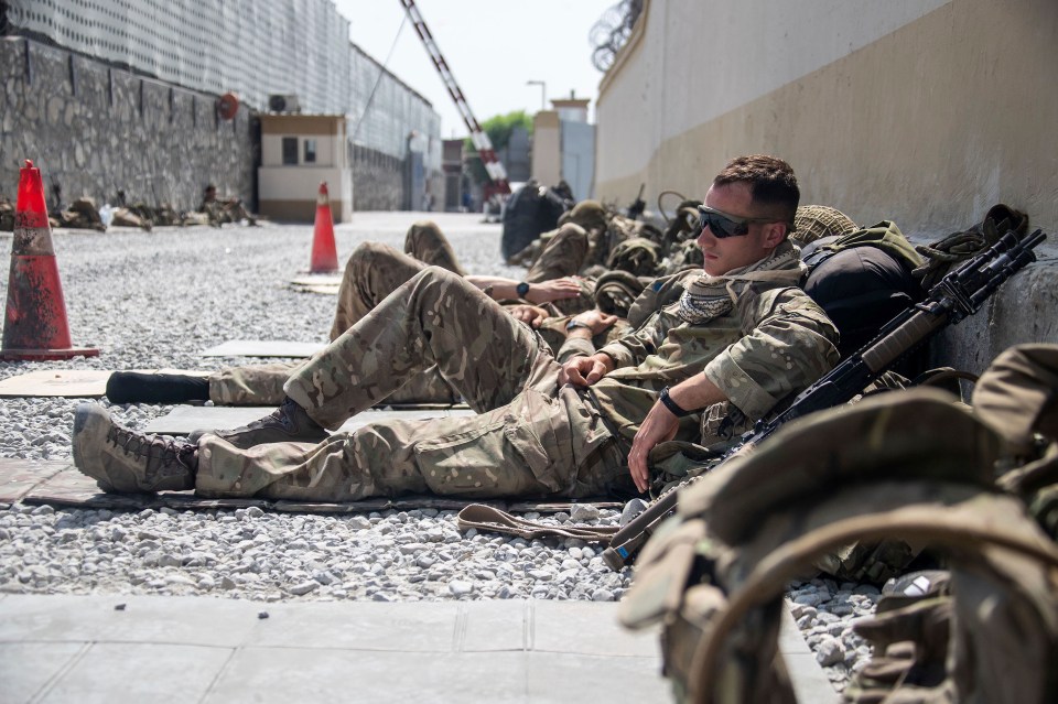 British soldiers take a break from working to evacuate personnel from Kabul airport yesterday