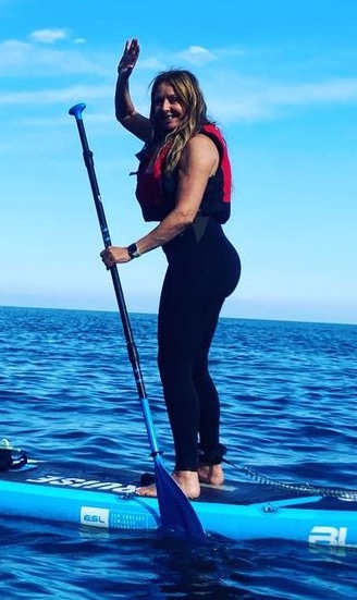 Carol takes a snap in her paddleboarding wetsuit