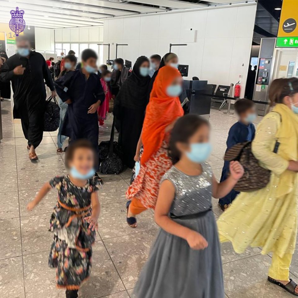 Relieved Afghans fleeing the Taliban arrive at Heathrow yesterday