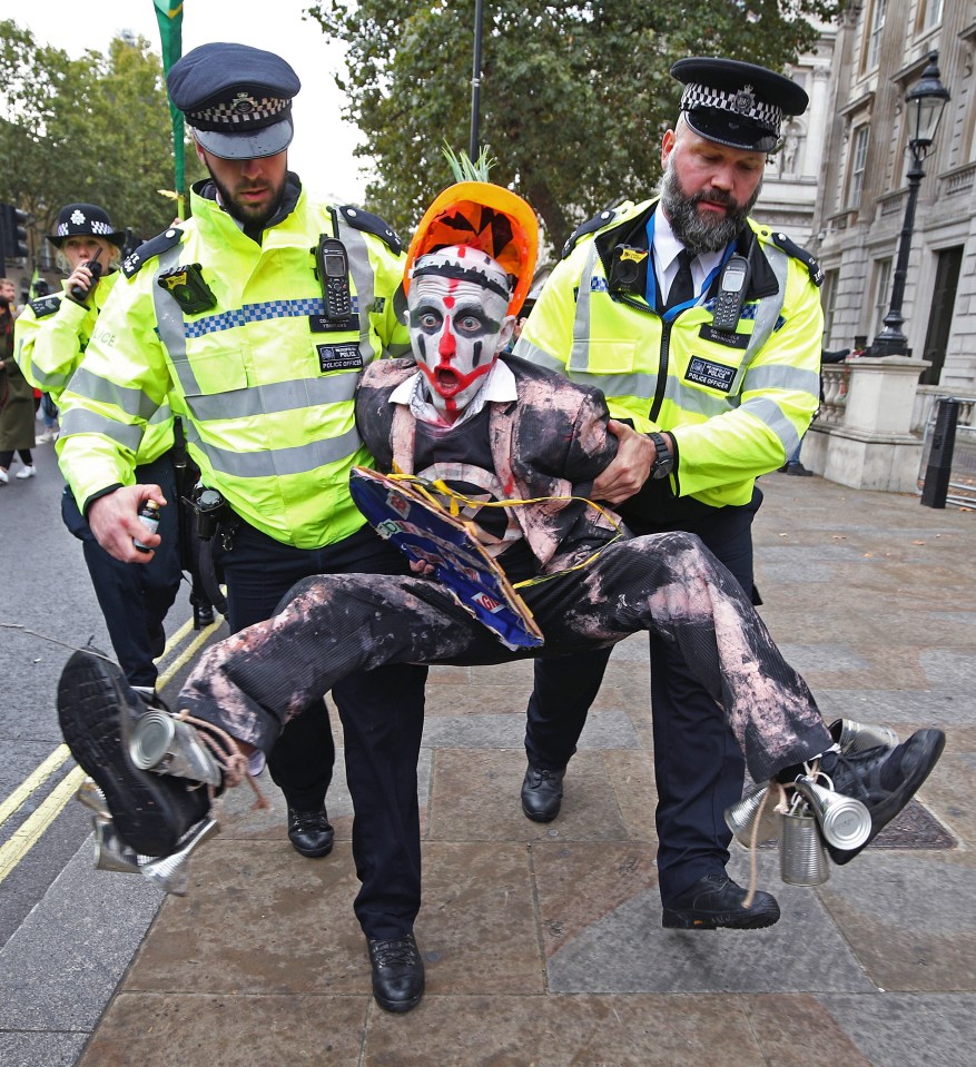 Police hold a protester during an Extinction Rebellion (XR) demonstration in Westminster, London, on October 7 2019