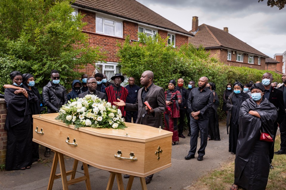 A Ghanaian funeral ceremony on June 5 2020, outside the London home of a man, 40, who died suddenly from suspected Covid. Snapped during the lockdown, his wife, family and friends could take part in the religious service