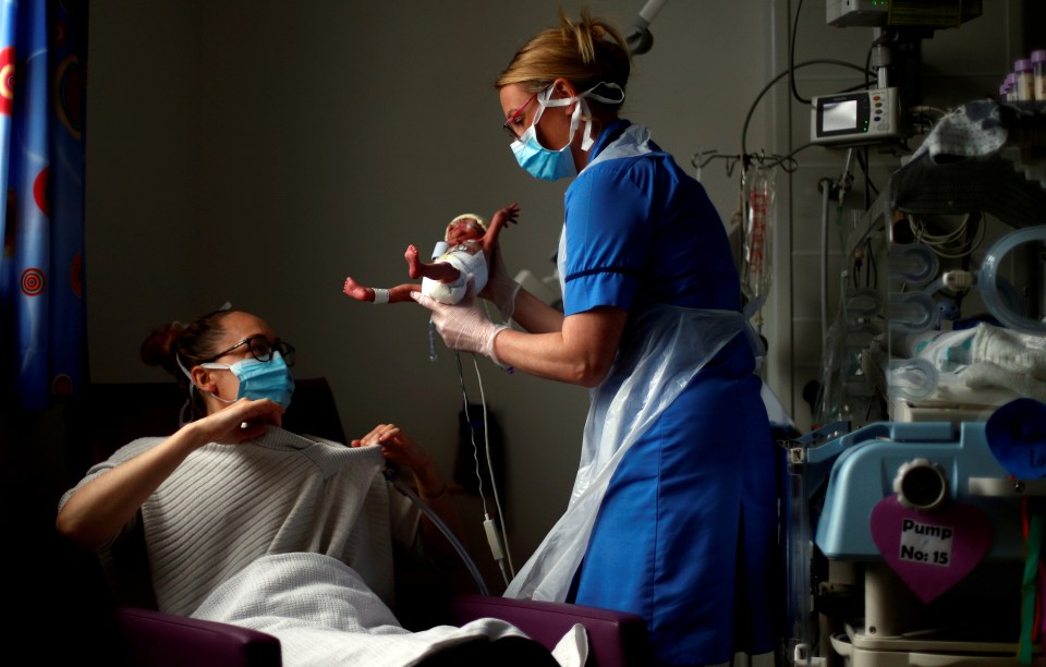 Neonatal nurse Kirsty Hartley carries premature baby Theo Anderson to his mum Kirsty Anderson in the Neonatal Intensive Care Unit at the Lancashire Women and Newborn Centre at Burnley General Hospital during the Covid outbreak, on May 15 2020