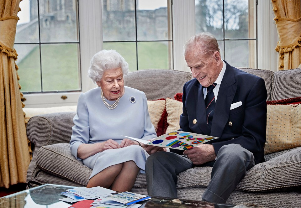 The Queen and the Duke of Edinburgh smile as they look through cards they received to celebrate their 73rd wedding anniversary, at Windsor Castle, November 17 2020