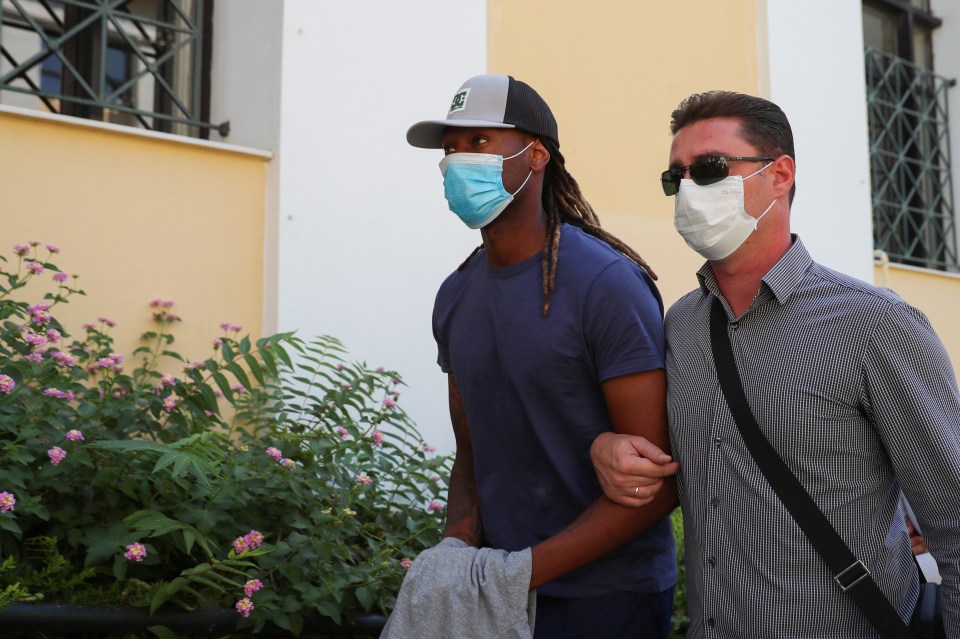 Ruben Semedo, left, is led by a plainclothes officer into the prosecutor's office